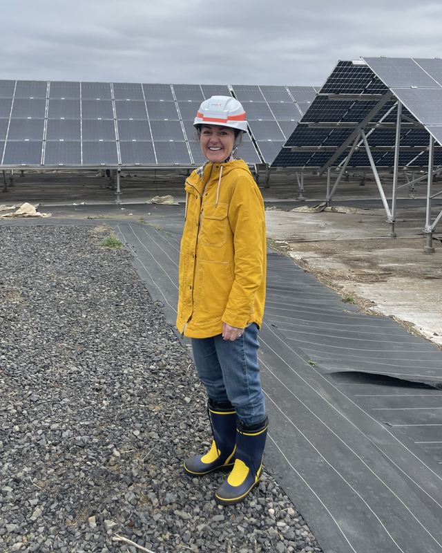 Michelle Propst in a hard hat and rain jacket at a utility-scale solar plant